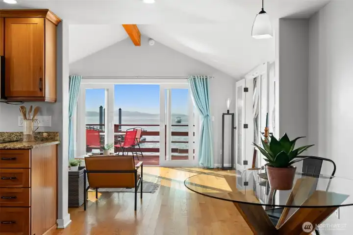 Dining area flowing into open living and deck, ideal for entertaining with views.