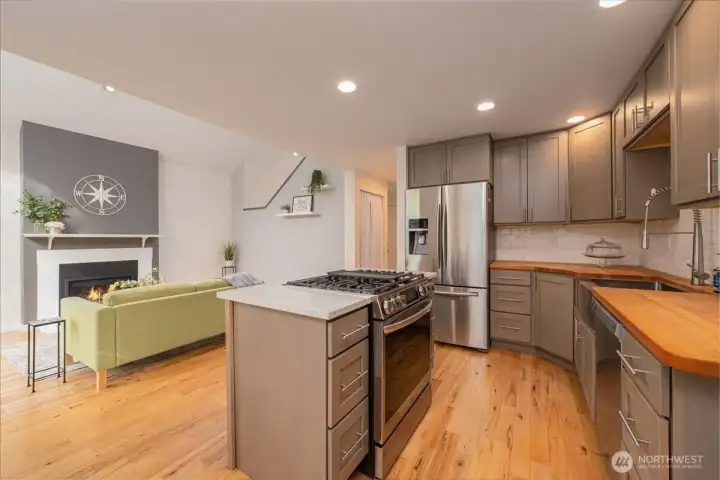 New gas stove with gridle allows you to see and talk to your guest while cooking. warm butcher block counter tops add to the warmth of the working kitchen.