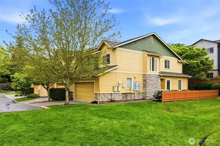 Modern exterior of this corner-unit townhome featuring extra windows and professional landscaping.
