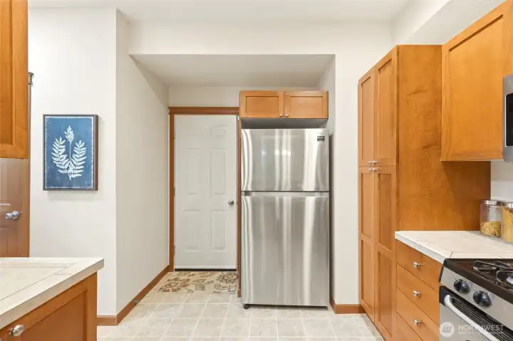 Detailed view of the kitchen’s stainless steel appliances and breakfast bar seating area.