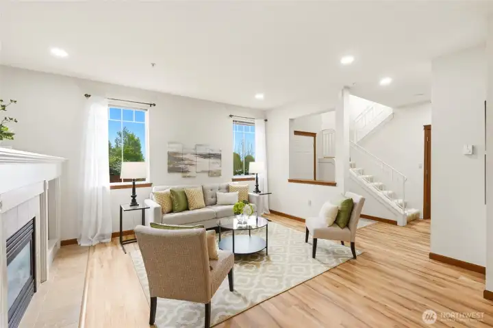 Light-filled living room with recessed lighting and views of the surrounding greenery.