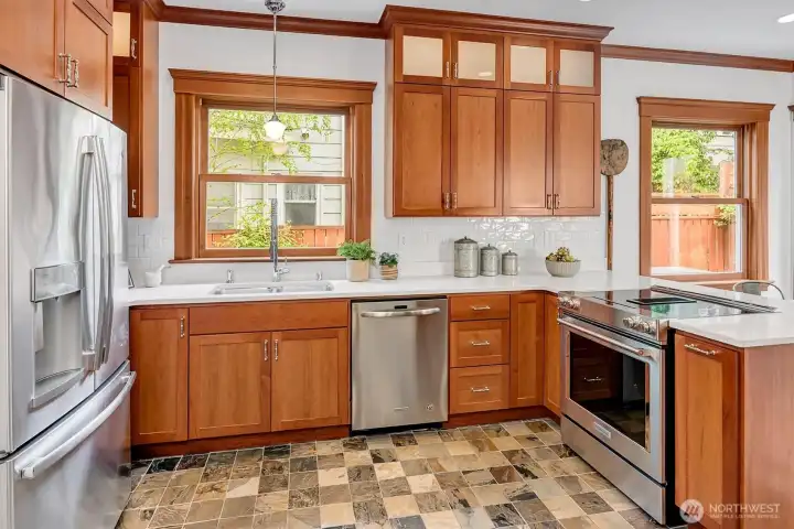 Sunny kitchen has stainless appliances, great supportive lighting, slate floors.