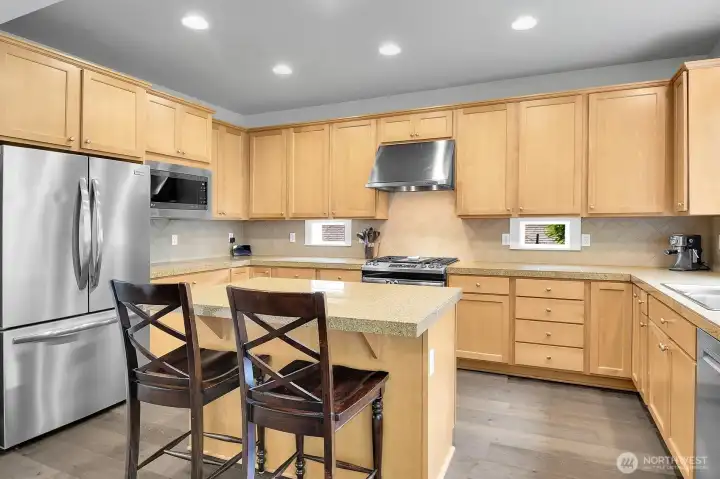 Chef's kitchen with stainless steel appliances, granite counters and new flooring.