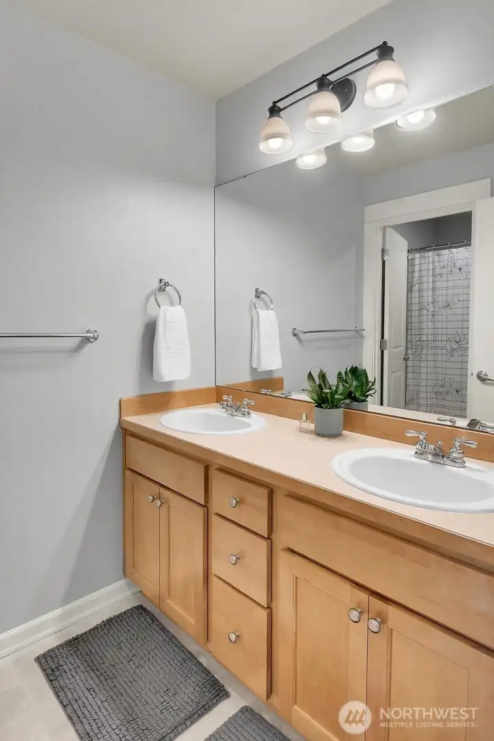 Upstairs bath offers dual sinks and ample cabinet storage.