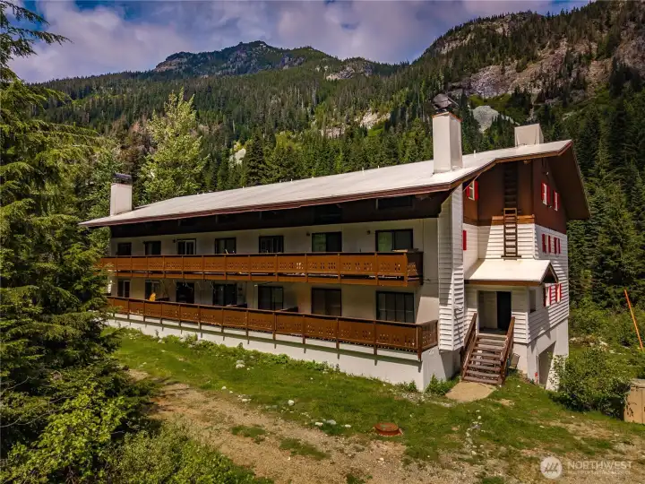 The subject building is surrounded by towering evergreens and stunning mountain scenery, offering a true four-season alpine lifestyle.