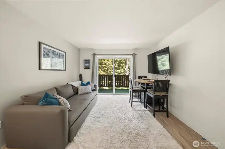 Bright studio living area with private balcony access and flexible space for relaxing, dining, and entertaining.