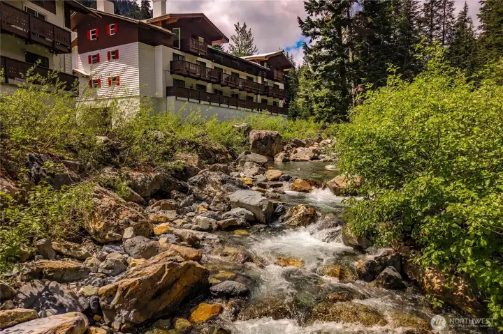 A year-round mountain stream flows alongside the building, creating a peaceful alpine setting filled with the soothing sounds of rushing water.