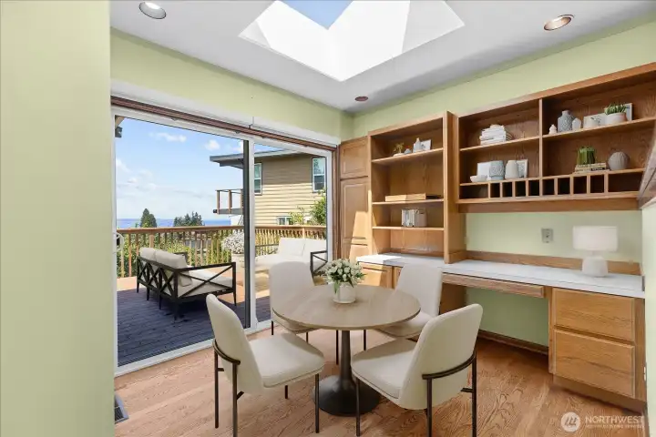 Kitchen eating area with hardwood flooring, skylight, extra storage and easy access to large front deck