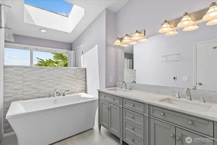Updated primary en-suite with new cabinetry, heated flooring and skylight