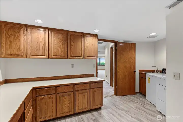 Oversized laundry room located off of the garage with tons of storage, counter space and utility sink