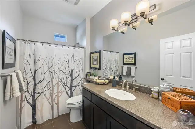 The main bath is adjacent to the second bedroom and has a bathtub for those who enjoy a soak! Also, an undermount sink, slab counter and tile floor.