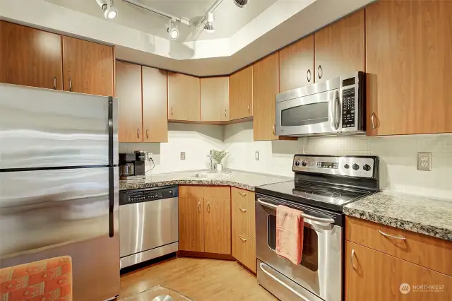 The kitchen features stainless steel appliances, granite counters, plenty of storage and custom lighting.