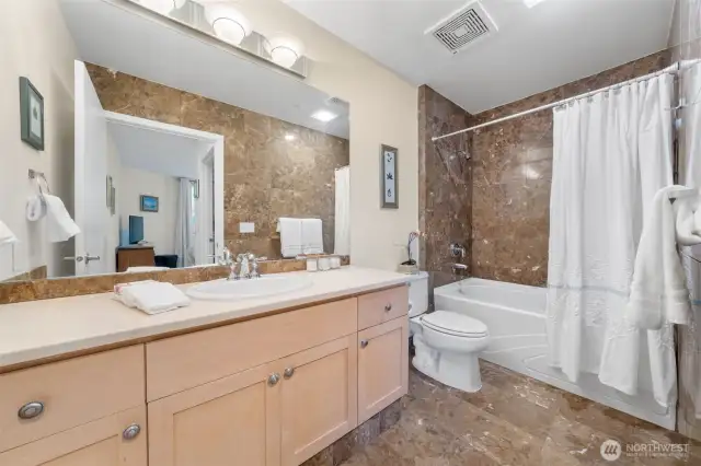 The Primary Bath showcases elegant marble tile, a deep soaking tub, and a wide vanity—blending everyday function with a spa-like feel.