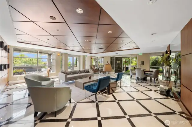 This alternate view of the elegant lobby showcases its refined finishes and natural light. Just outside, residents can enjoy a shared yet tucked-away patio that wraps around the building—offering peaceful spots to relax and take in beautiful views of Lake Washington