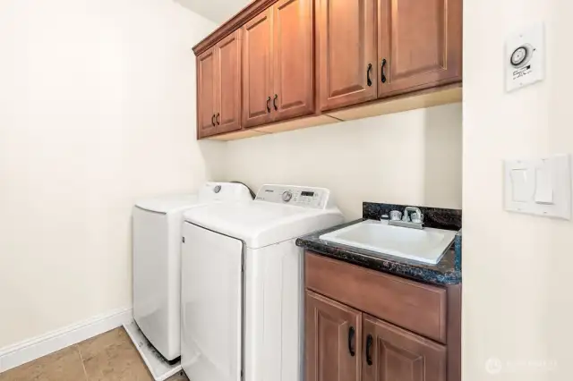 Upper level laundry room with the cabinets and sink