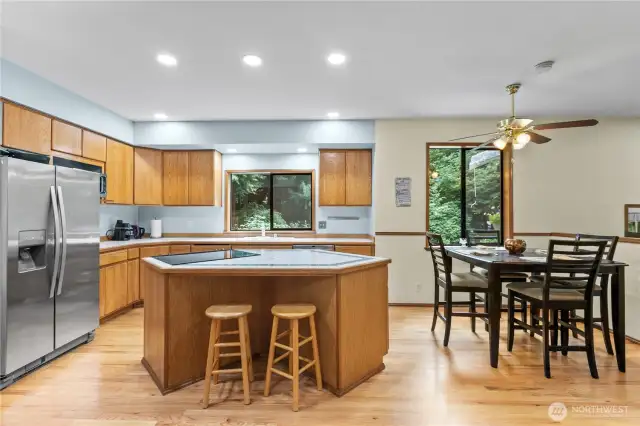 Island and sink overlook the peaceful backyard and garden