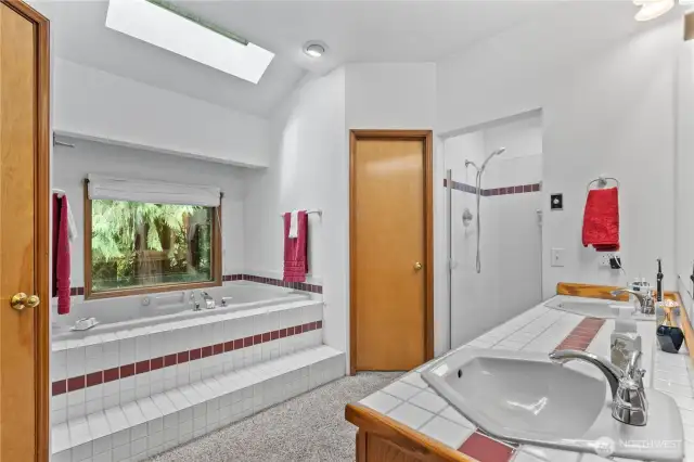 Attached 5-piece bathroom has skylights