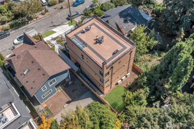Aerial view of back elevation, rooftop deck, & fenced yard.