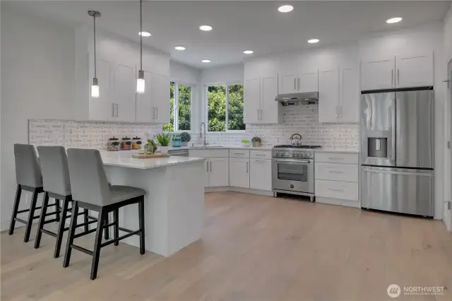 Unit B spacious main floor kitchen with eating bar & quality finishes/features throughout.