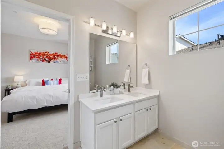 Primary bath with newer dual vanity, quartz counters, new lighting and tile floors