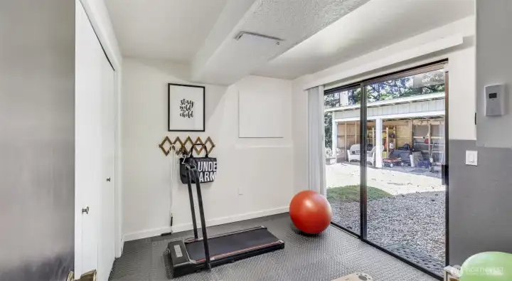Located just off the lower level living and theatre room, this versatile area is perfect for a home gym, workout space, or cozy den with easy access to the lush grounds outside.