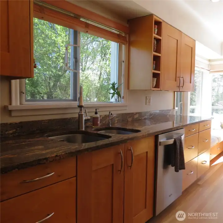 Entering the kitchen with newer stainless appliances, granite countertops, tons of storage, and a built-in corner nook seating area.