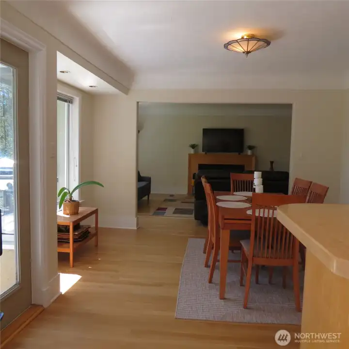 Looking into the dining room from the kitchen corner nook. Door to the left is access to the main level back deck with ample seating and BBQ. Note how well the space flows from kitchen to dining to living room to deck—perfect for entertaining.