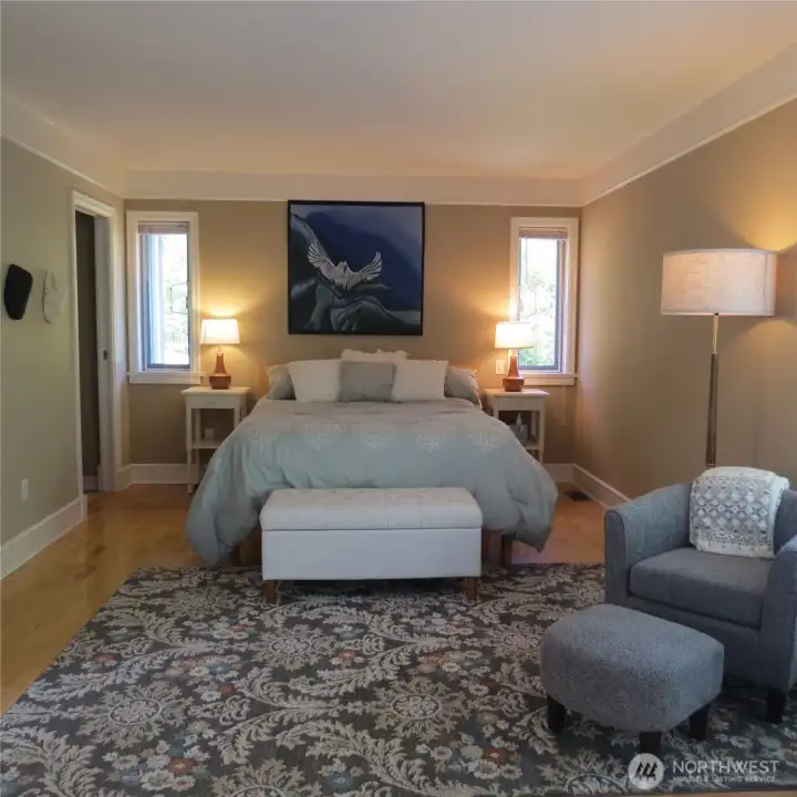 Primary suite. Walk-in closet is out of frame and door to attached bath can be seen in back left corner.