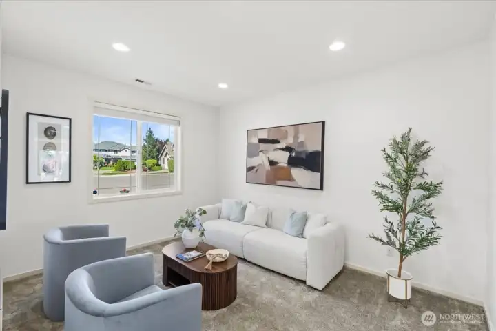 Bright front living space with large picture window, recessed lighting, and soft neutral finishes. A comfortable layout creates an inviting area for conversation or relaxation.