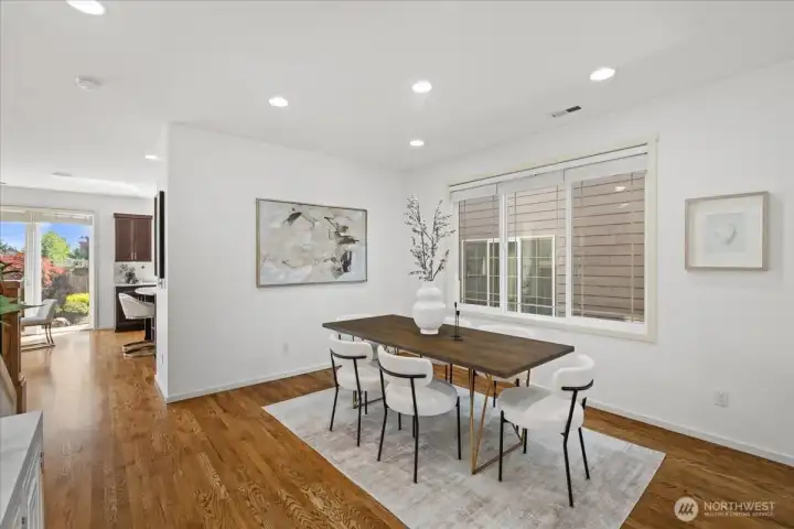 Dedicated dining space with hardwood floors, oversized window, and recessed lighting. Ideal for everyday dining or hosting gatherings.