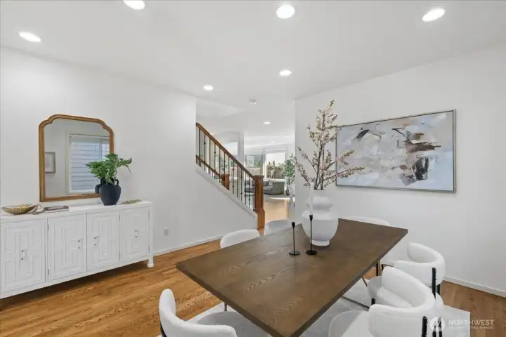 Spacious formal dining area with warm hardwood flooring, contemporary lighting, and convenient access to adjoining living spaces.