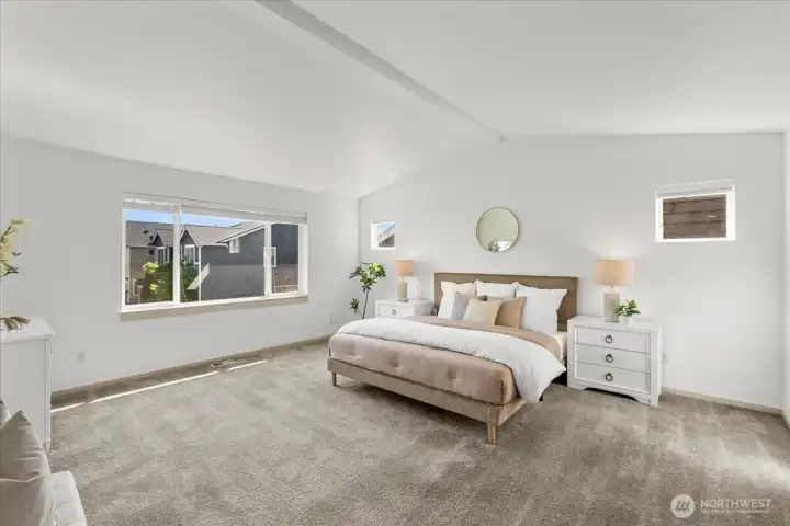 Spacious primary suite featuring vaulted ceilings, oversized windows, and abundant natural light. Generous proportions create a relaxing retreat.