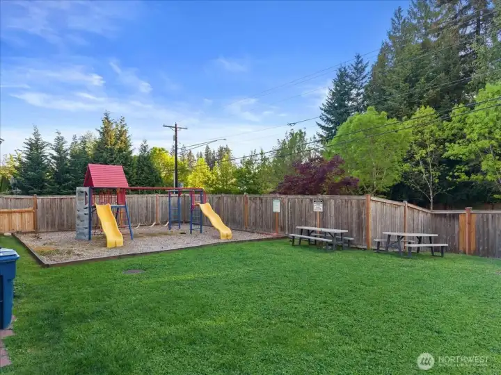 Community park area featuring open green space, playground equipment, and picnic seating. Convenient neighborhood amenity for outdoor recreation and gathering.