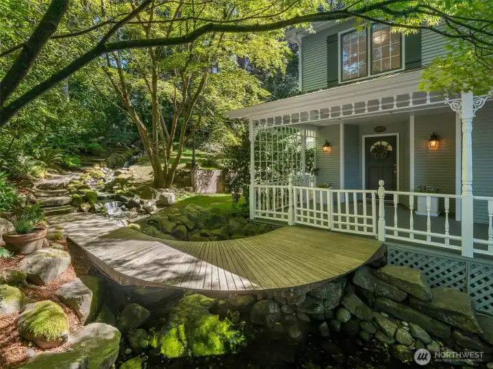 Cross the curved bridge above a sparkling stream and arrive at a home that feels worlds away.