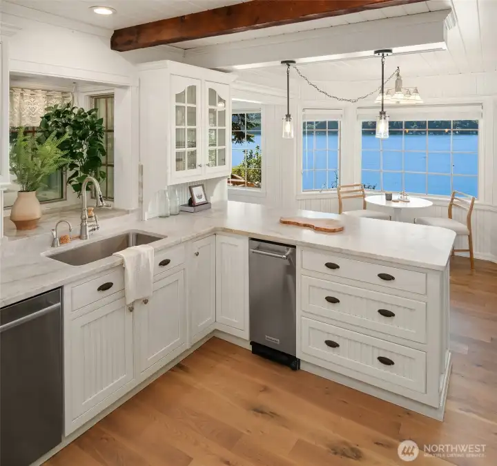 Light-filled kitchen with expansive waterfront views and seamless connection to the dining nook and dining room.