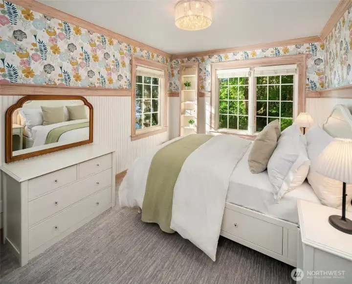Charming bedroom with custom millwork, whimsical designer wallpaper, with water and garden views