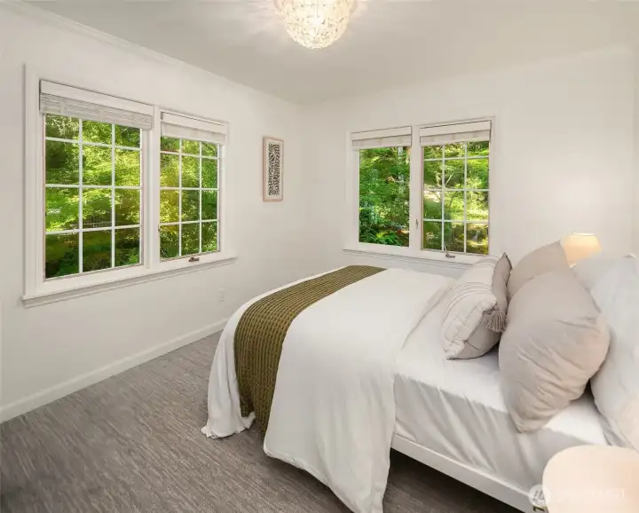 Peaceful bedroom overlooking lush gardens and mature landscaping.