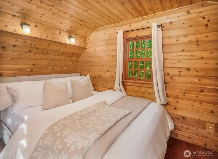 Charming guest sleeping area tucked within the cozy cabin setting.