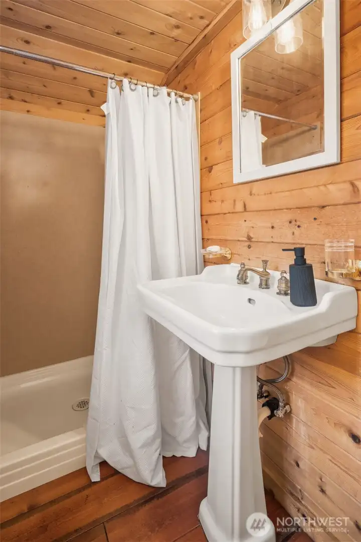 The rustic bathroom reflects the cottage's authentic cabin aesthetic, blending simplicity, warmth, and comfort.