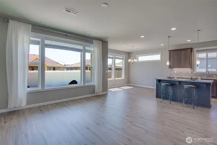 Family Room looking toward Kitchen, and Dining Space from private hall to primary suite.  Ceiling fan connection and forced air vents are shown in the ceiling.
