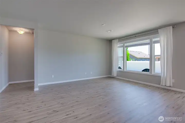 Family room and private hall to primary suite from kitchen.  Large South facing family room windows.