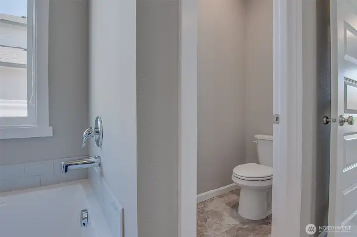 Primary Bathroom soaking tub and water closet with soft close toilet seat from double vanity
