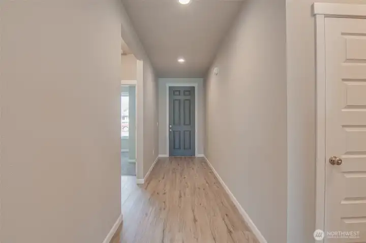 Entry Hall looking at front door from family room.  Garage Door and laundry room are on the right, Bedroom 2 & 3 and 2nd bathroom are on the left.