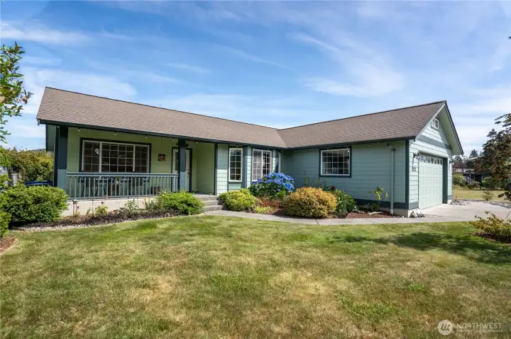 Wide view of the front exterior and landscaped yard.