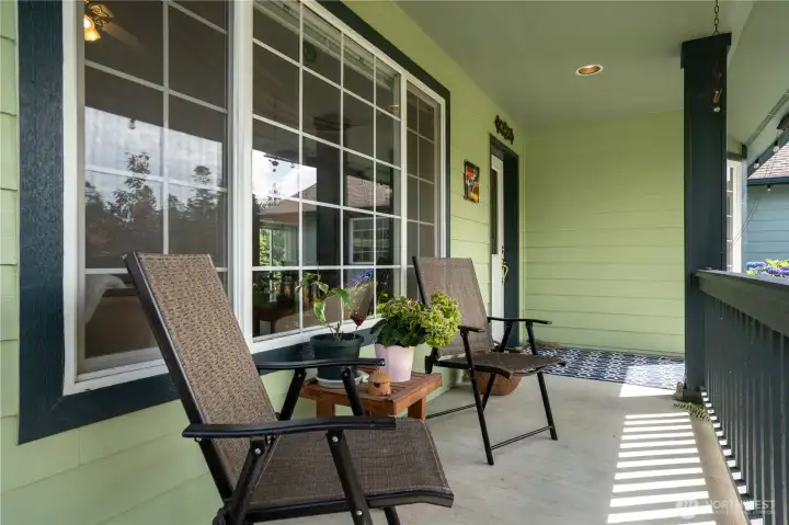 Welcoming covered front porch with seating area.