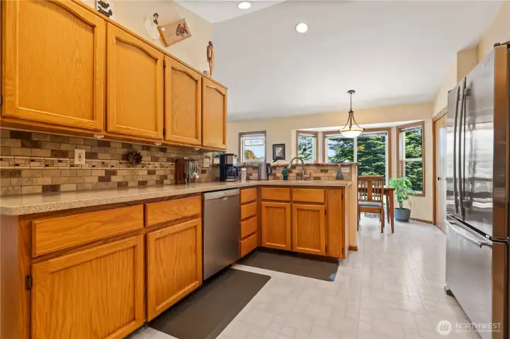 Kitchen with abundant cabinetry and tile backsplash.