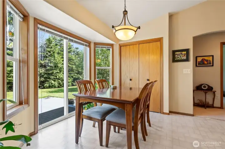 Dining area with large windows overlooking the backyard.