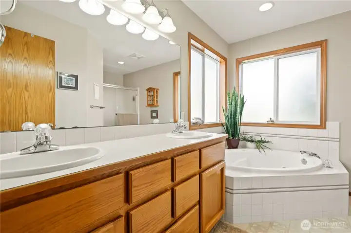 Primary bath with dual vanities and soaking tub.