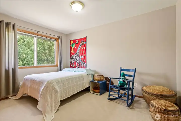 Spacious guest bedroom with large window and natural light.