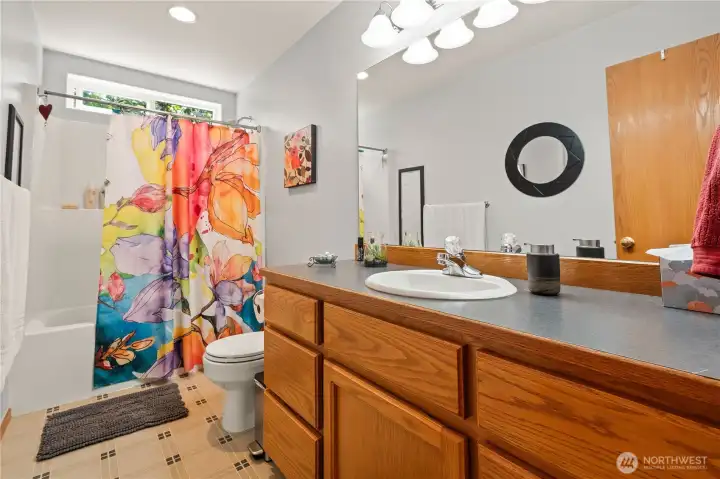Full guest bath with oversized vanity and tub/shower combination.